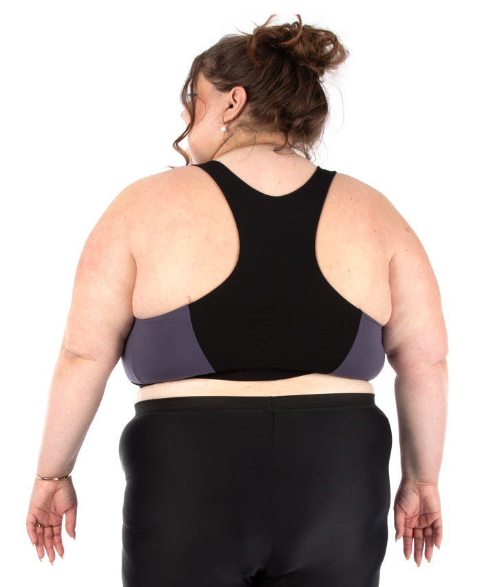Person wearing a black sports bra and shorts set on a white background