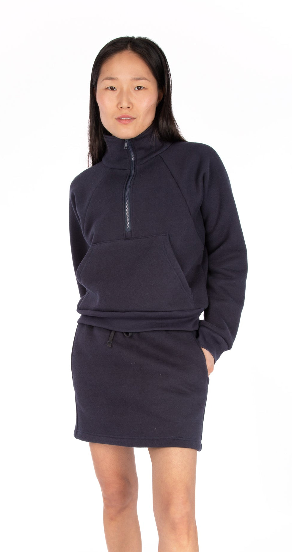 Woman wearing a navy fleece Sophie cropped half-zip sweatshirt with a fleece skirt, both made with Jalie patterns