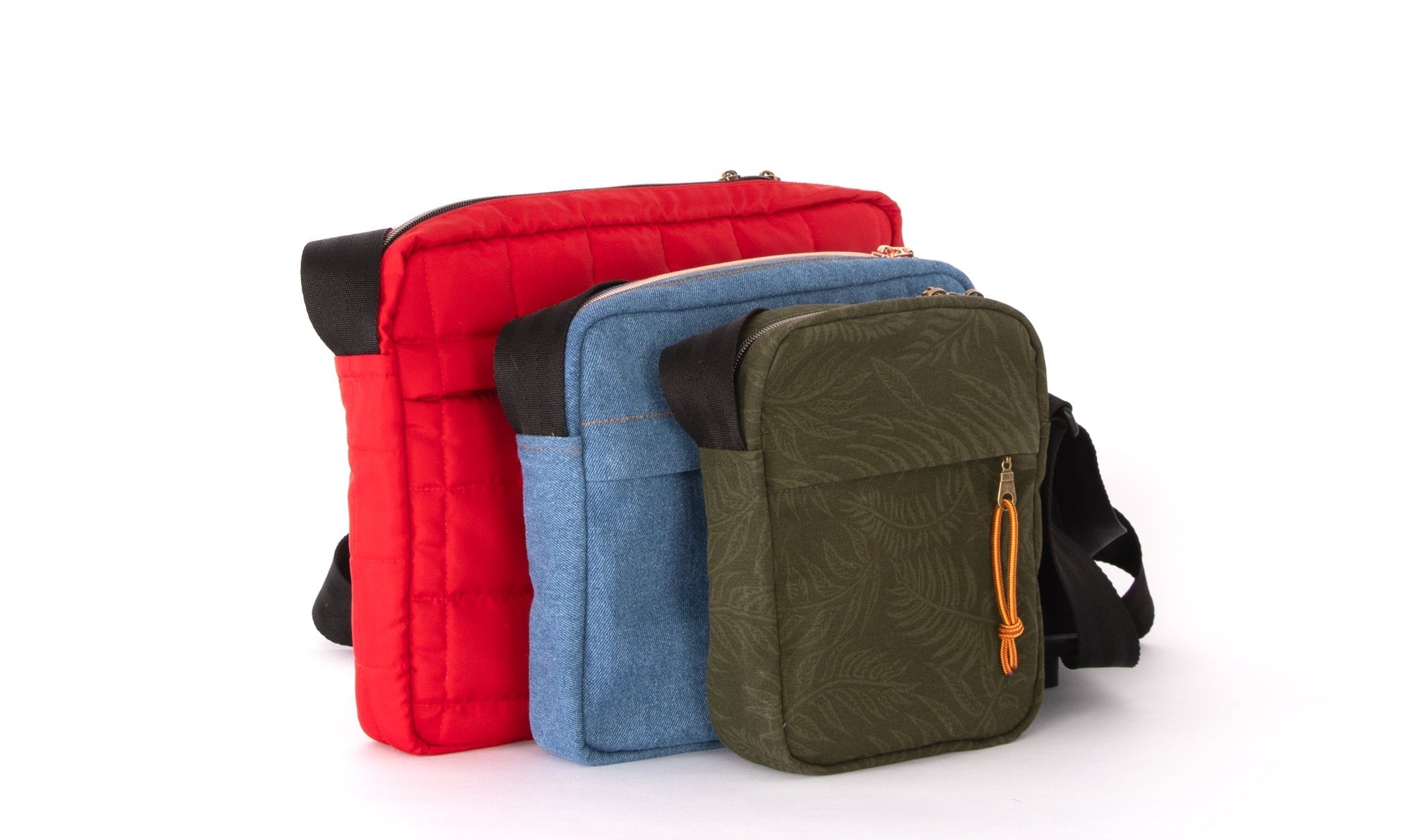 Three Galaxy 7 Pixel crossbody bags in red, blue, and olive green are displayed against a white background with size indicators L, M, and S at the bottom.
